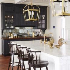 Marble-Topped Kitchen Island With Oversized Pendant Lights Overhead