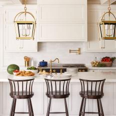 Barstools Lined Up at White Island in Traditional Kitchen