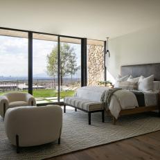 Neutral Contemporary Bedroom With Sitting Area and Wall of Windows