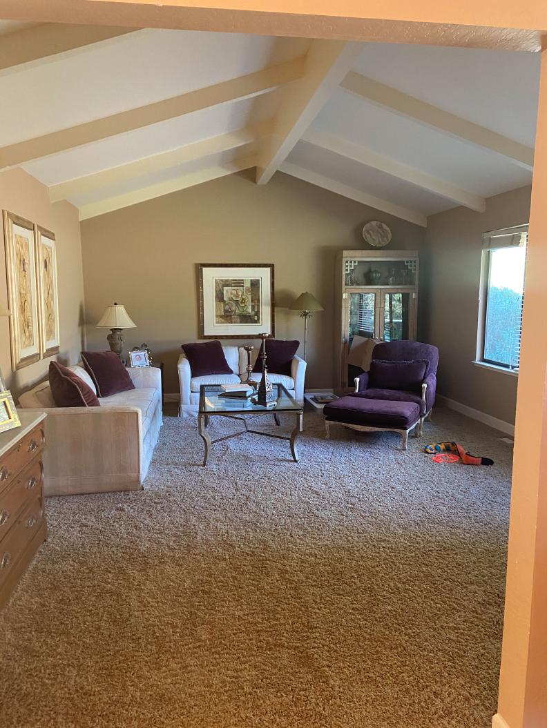 Before the renovation, the living room featured drab carpet and dated decor. 