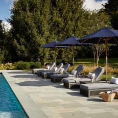 Gray Patio Loungers Lined Up on Concrete Pool Deck