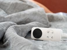 controller of an electric blanket with a human sleeping at the background at horizontal composition