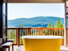 This outdoor bathtub features mountains on deck behind it.