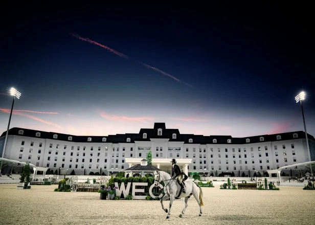 A sunset with the World Equestrian Center in Ocala, Florida, in the background and a rider on a horse.