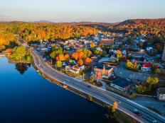An aerial view of highways, houses and trees in the Adirondacks in fall.