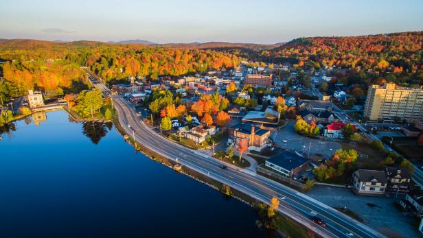 An aerial view of highways, houses and trees in the Adirondacks in fall.