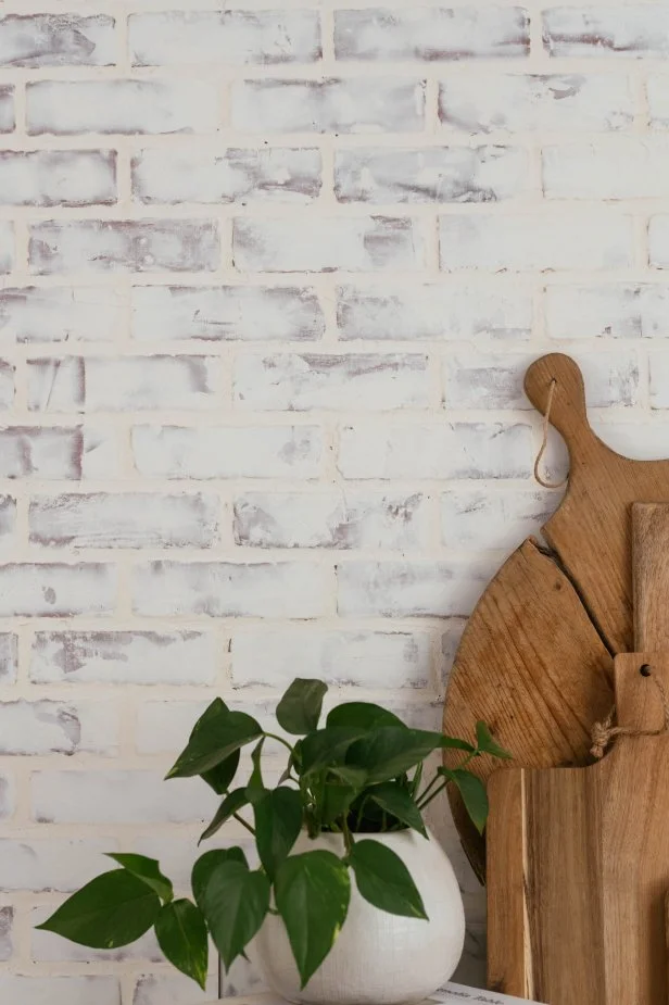 This faux brick kitchen backsplash gets a 'German schmear' treatment (sometimes called a mortar wash), creating the classic, patinaed look that's characteristic of the home-exterior masonry technique.