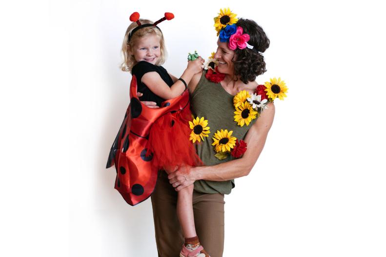 Woman dressed as a flower with child in a ladybug costume