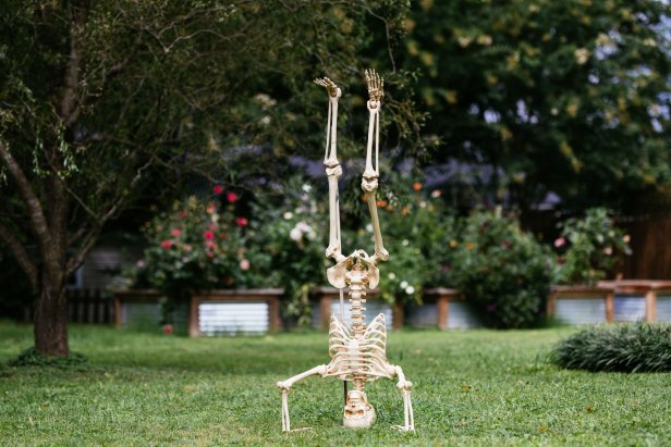 Skeleton doing a handstand in the front yard.