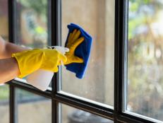 Close-up of a restaurant worker's hand cleaning a window glass and spraying disinfectants during the outbreak of the virus Use a cleaner or use alcohol to disinfect the restaurant.