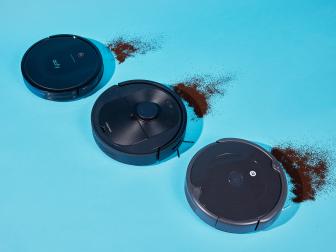 Three robot vacuums vacuuming up coffee grounds
