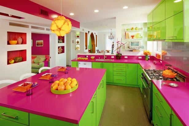 Modern kitchen with white walls, pink countertops and green storage.