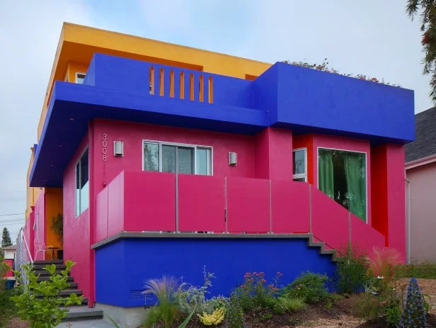 Blocky pink midcentury home with blue and marigold accents.