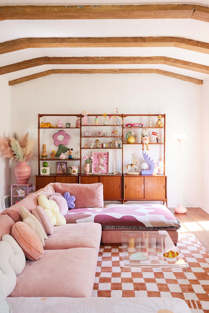 Living room with exposed beams and large pink sectional.