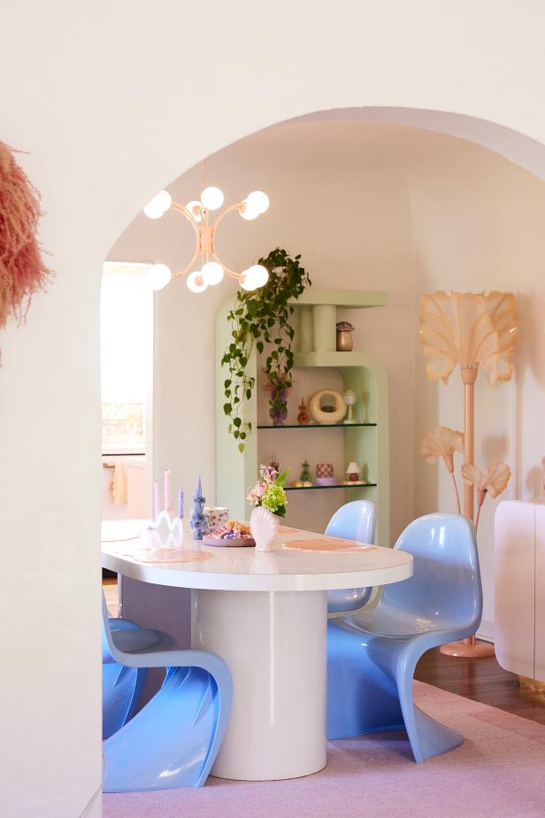 Arched door into dining room with pastel retro furniture. 
