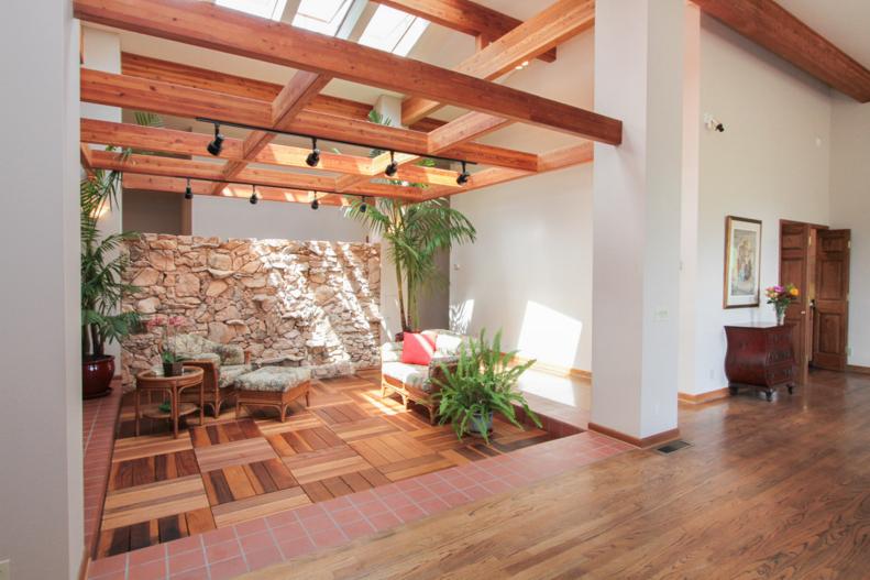 Neutral indoor atrium with exposed beams and wood parquet floor. 