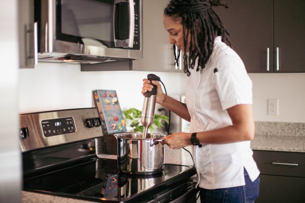 A photo of Chef Cris Ravarré using an immersion blender.