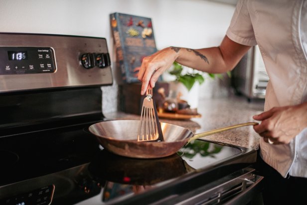 A photo of Chef Cris Ravarré using a fish spatula with a silicone tip.