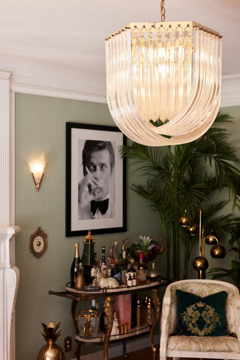 Pale green room with glass pendant, black and white photo and bar.
