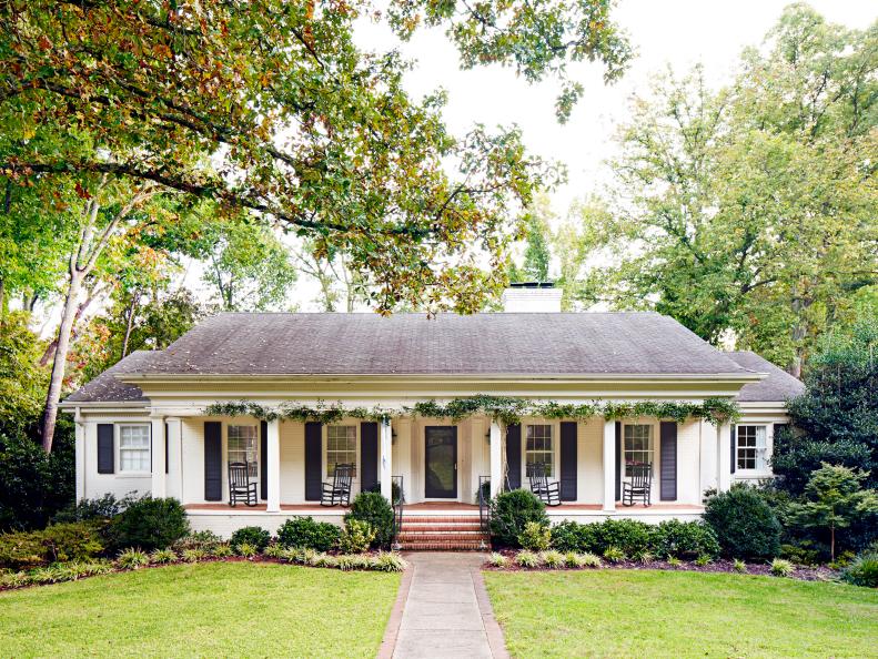 White Ranch Home With Black Shutters and Climbing Vines