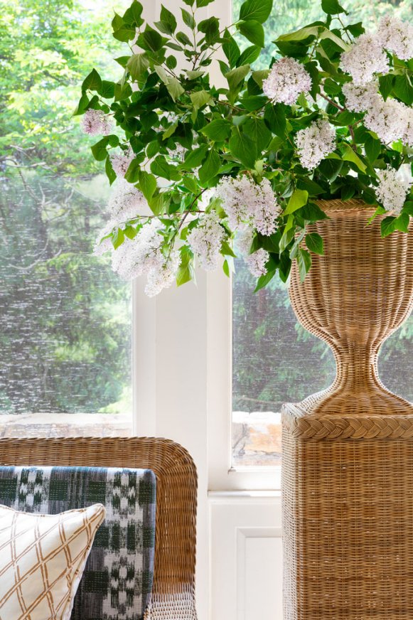 This sunroom takes classic wicker furniture to the next level with a stunning wicker planter filled with blooming hydrangeas.