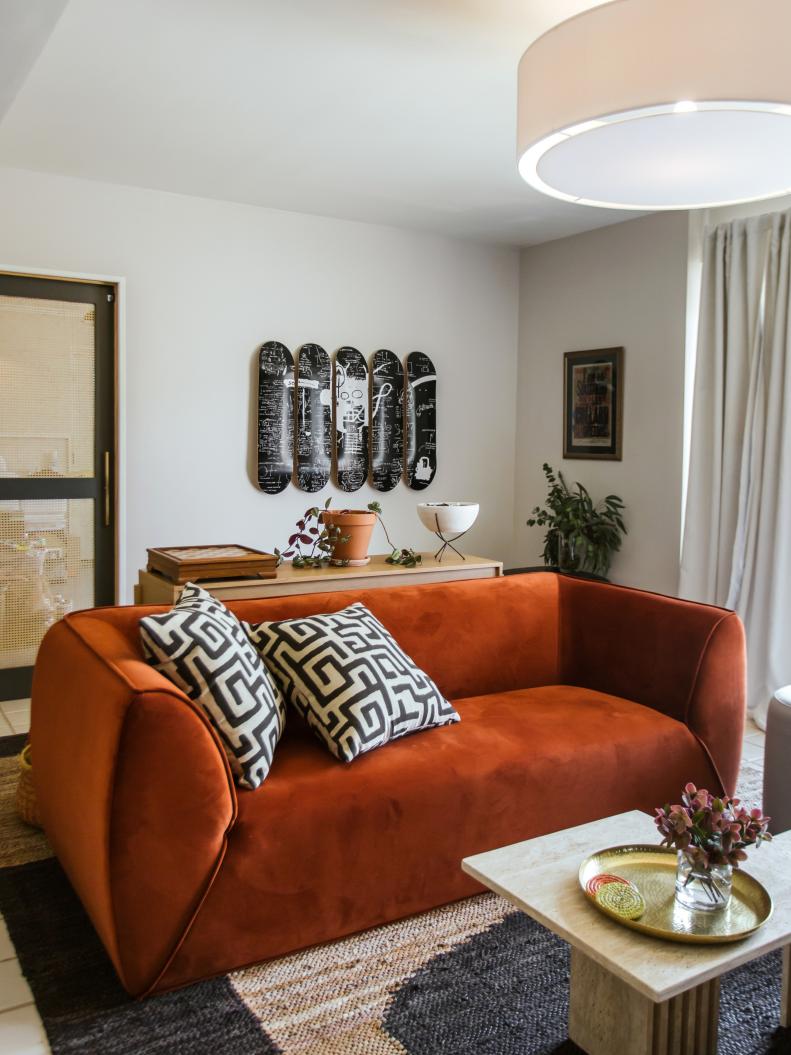 A photo of a living room with a rust colored sofa.