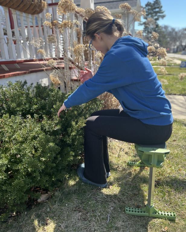 Woman gardening while sitting on a gardening seat