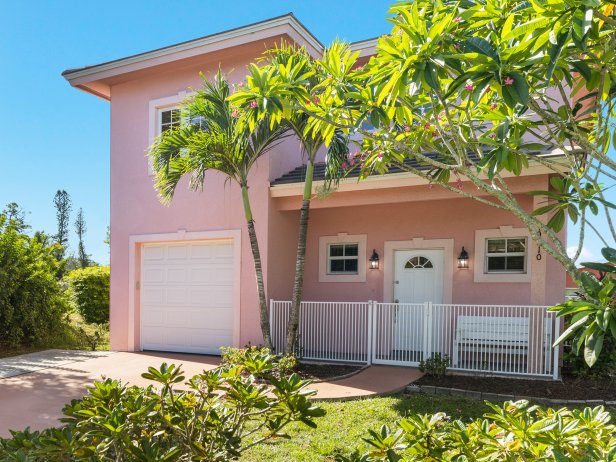 Pink House With Pink Trim and Palm Trees in the Front Yard