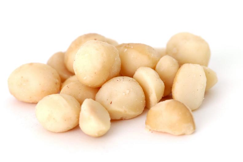 "a small pile of shelled macadamia nuts, isolated on white"