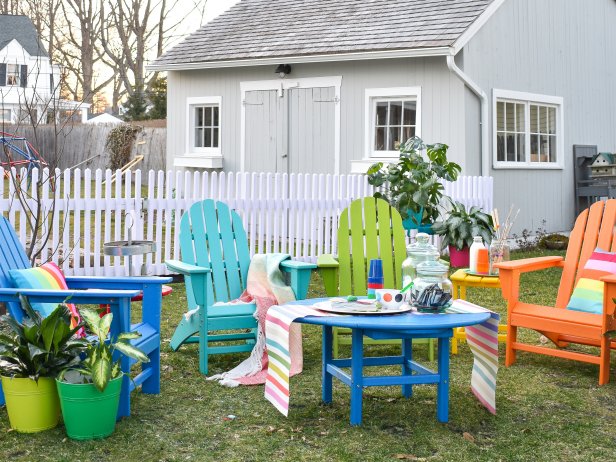 Colorful Backyard With Mismatched Outdoor Chairs and Rainbow Pillows