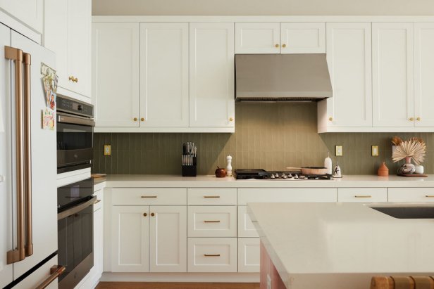 Kitchen with shaker cabinets, gold hardware, and green backsplash