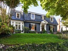 Blue Dutch Colonial Home With White Trim and Black Shutters