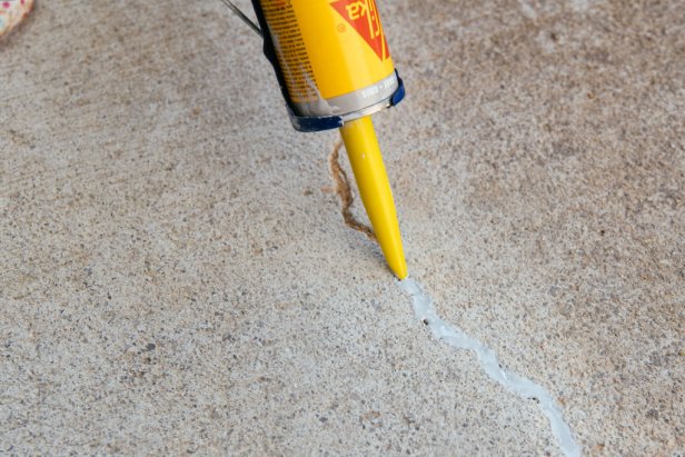 Run a bead of sealant along the crack in the concrete being sure the sealant fills the gap.