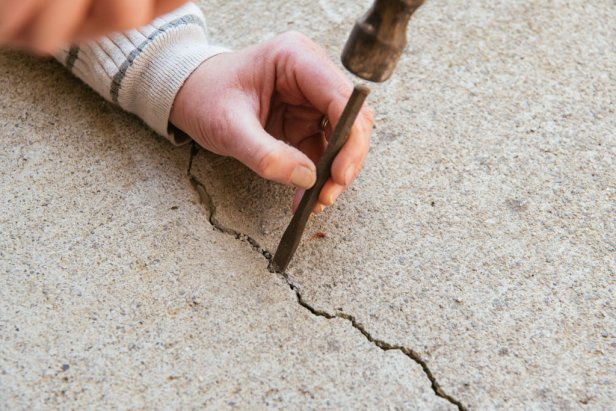 Use a chisel placed into the center of the crack to widen the crack in the shape of a &quot;V&quot; until the crack is at least 1/4-inch wide. Chip away any loose or crumbling concrete.