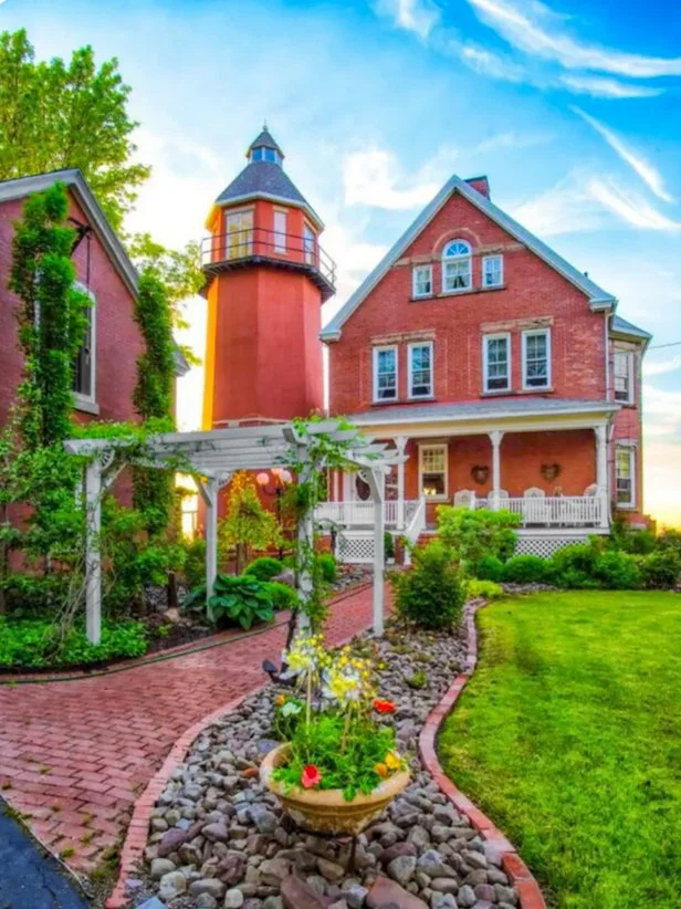 Red, Northeastern Lighthouse With a Brick Path and Arbor