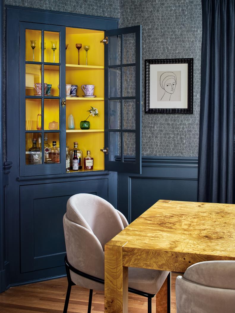 Dark Blue Dining Room With a Yellow Hutch