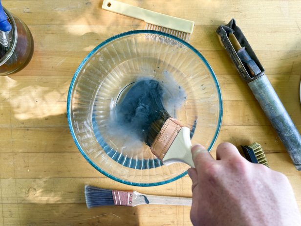 cleaning a paint brush in warm water