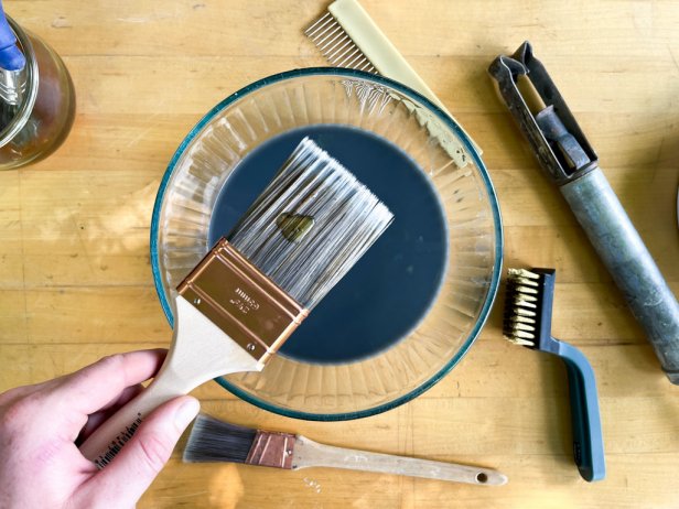 The next step in cleaning a paint brush is to place a small amount of dish soap on the bristles to rid them of any stubborn paint.