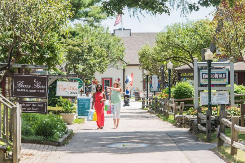 Two women shoppers walking past the downtown shops in Mystic, CT