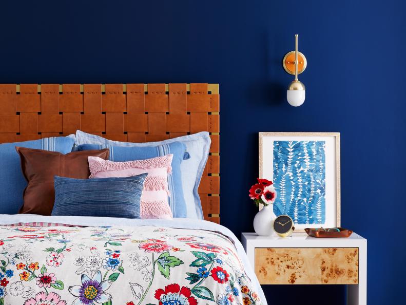 Bedroom With Dark Blue Walls, Floral Comforter and a Woven Bed Frame