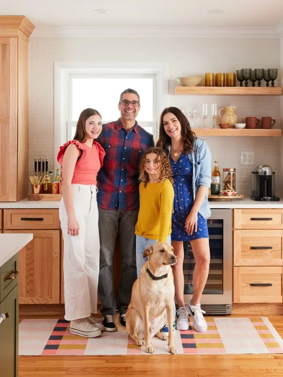 Family Posed in Their White Kitchen With Wood Cabinets