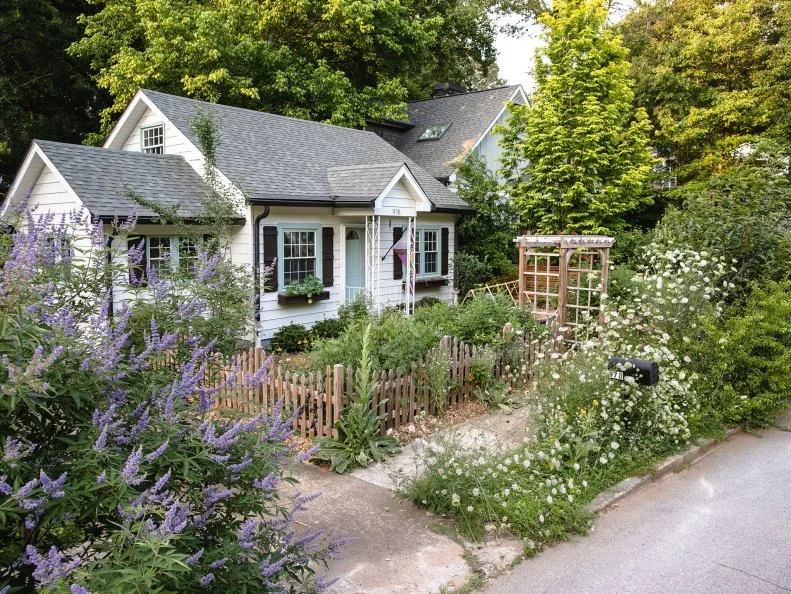 A house with mulch and plants in the front yard instead of grass.