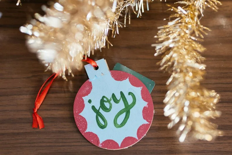 A hand-painted wooden ornament turns a gift card into an heirloom.