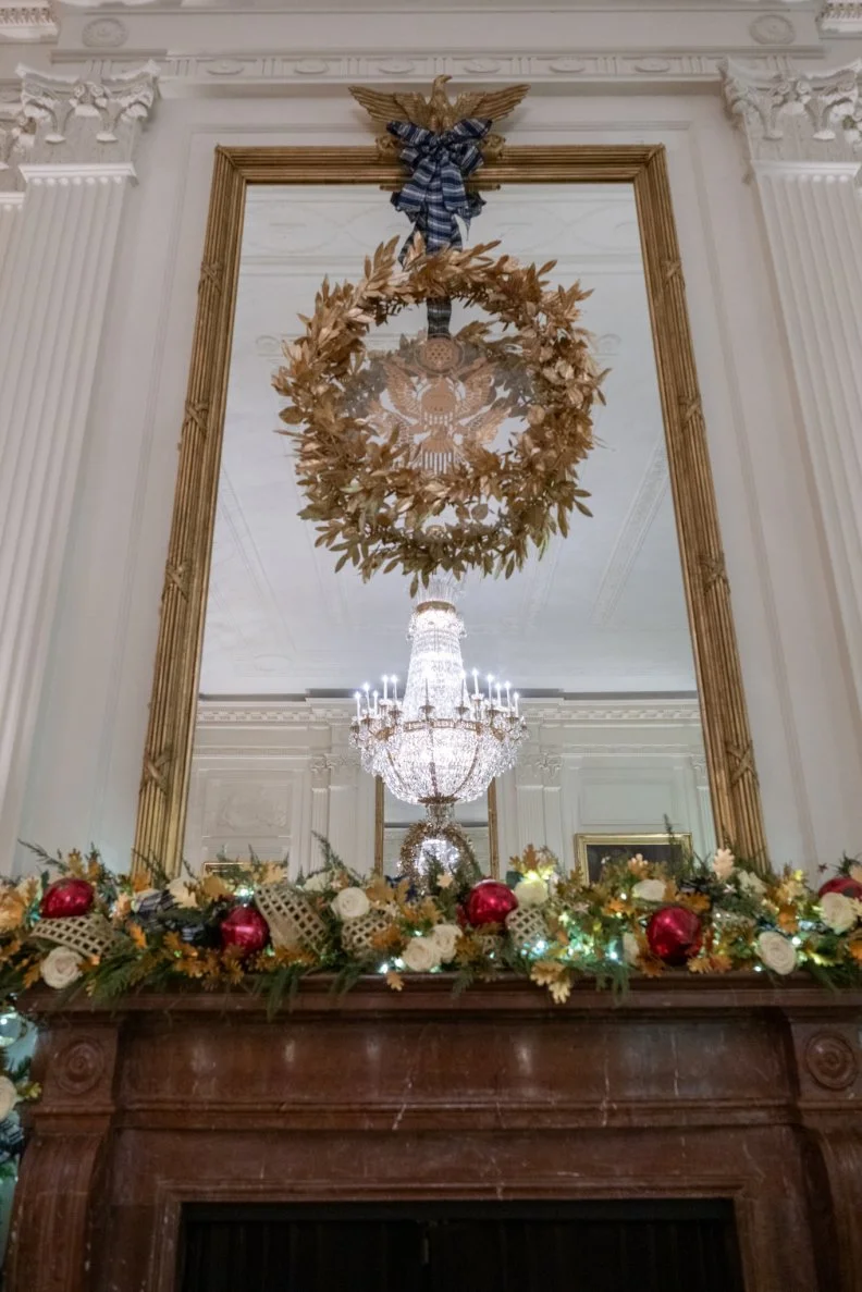 The entire White House has taken full advantage of the dramatic mantles that define this historic home but the East Room offers one of the most spectacular displays with its festive glass globes rendered more lovely when capped by a gold wreath and with a glowing chandelier reflected in an enormous gilt mirror.