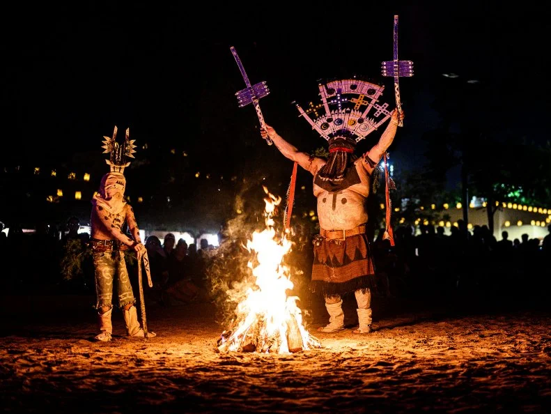 Dancers in Native American garb dancing around a fire at the New Mexico State Fair