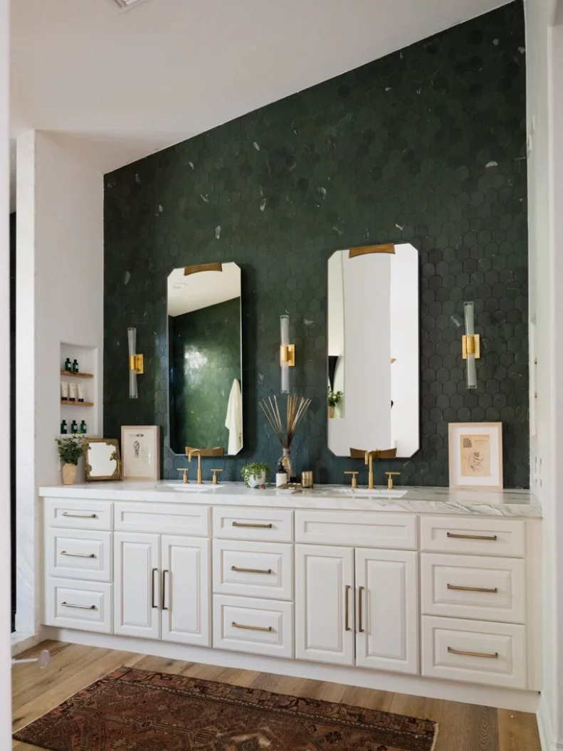 HGTV host Alison Victoria is a skincare junkie and this spa-like bathroom featuring on trend green tile offers plenty of cabinet space and open shelving to keep her many products.