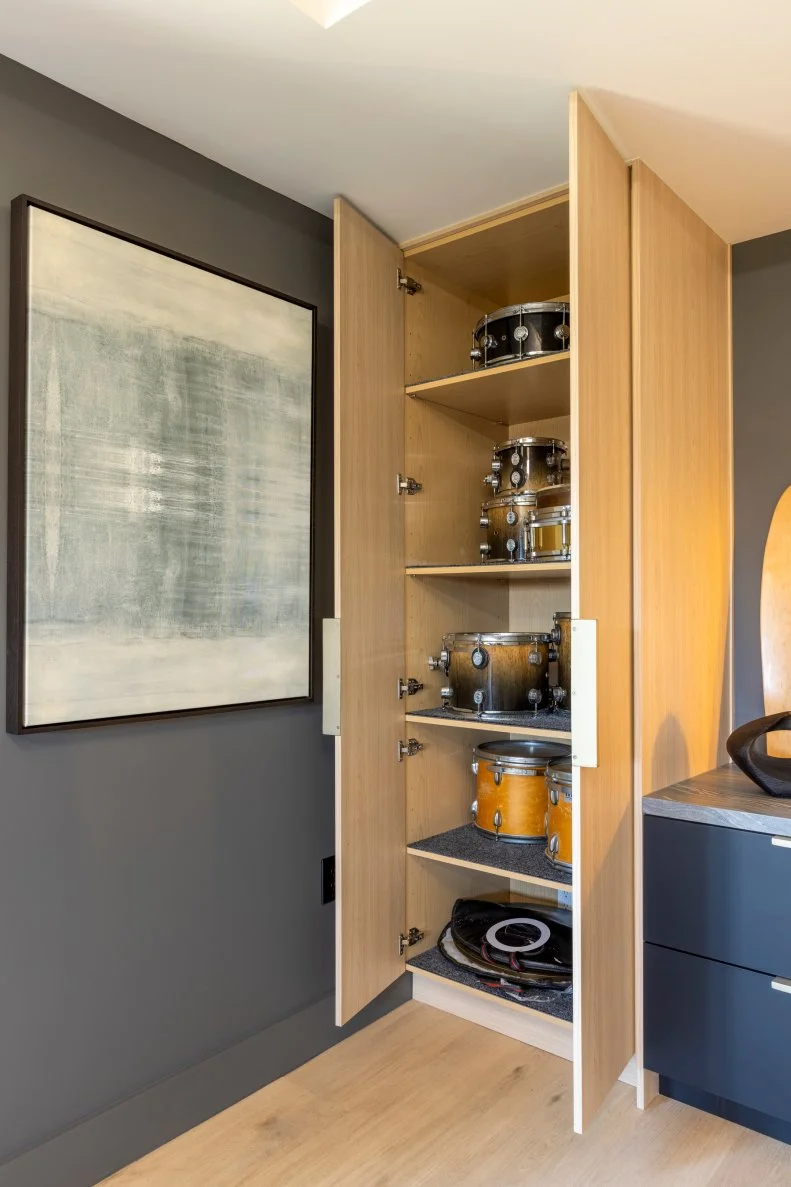 In what might be a design first, the Property Brothers created this clever floor to ceiling cabinet to house Ken's drums when they aren't in use.