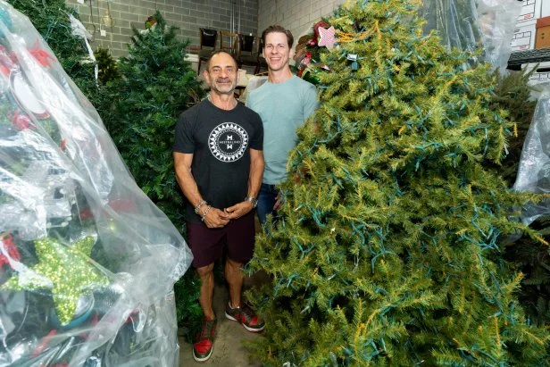 Homeowners Dominick Marangi and Matt Tumminello pose in the warehouse, as seen on Holiday Hoarders, Season 1.