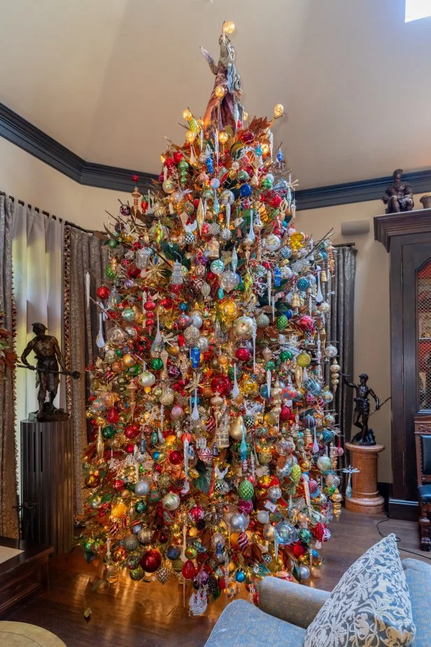Homeowners Dominick Marangi and Matt Tumminello’s living room featuring a large Christmas tree, as seen on Holiday Hoarders, Season 1.