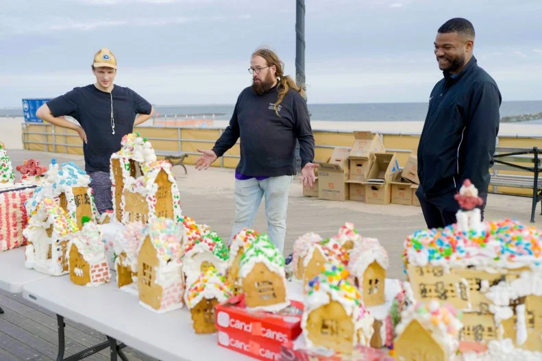 Jon on the boardwalk showcasing his gingerbread houses to the locals, as seen on Hoarding for the Holidays, Season 1.